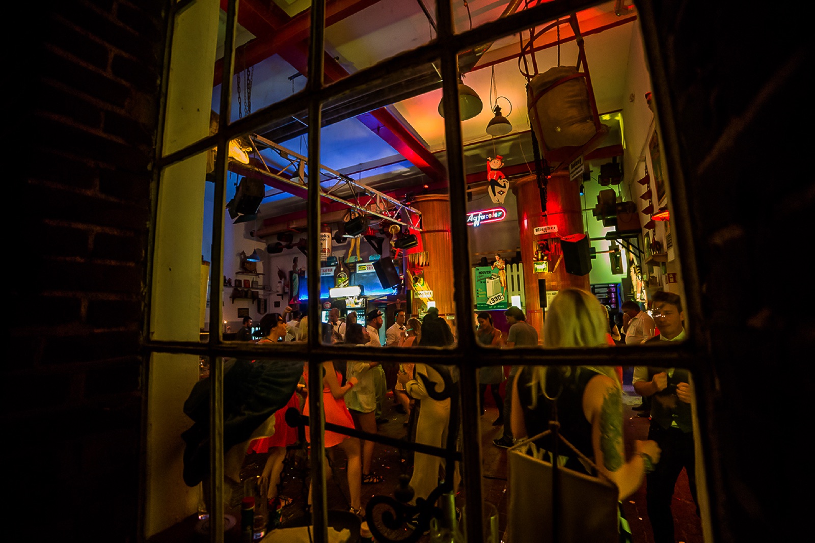Blick durch ein historisches Fenster auf eine Feier in der Mischerhalle