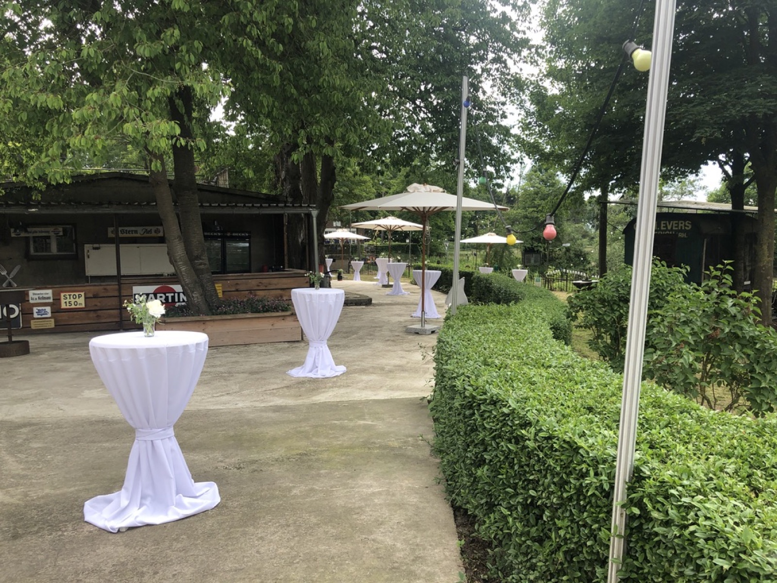 Terrasse mit weißen Stehtischen für einen Empfang